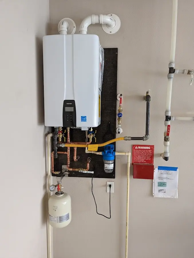 Professional plumber installing copper piping in a West Warwick home